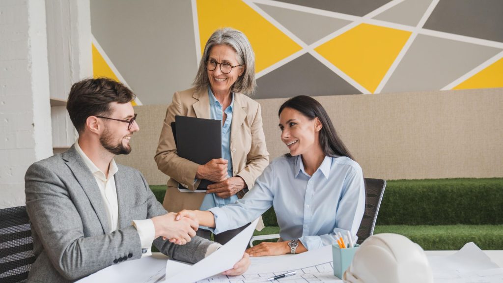 Business professionals shaking hands after securing interest only business loan funding for project